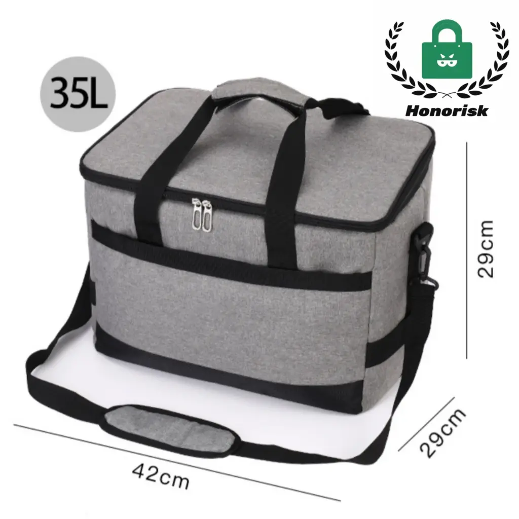 Outdoor picnic tote bag open on a blanket, showing the insulated compartment and utensil pouch.