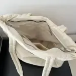 Moviy ko'k puffeal sumka, asosiy bo'linma va ichki cho'ntagidan iborat, yuqoridan suratga olingan.