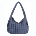 Tikattu turvonnut käsilaukku sinisellä kaarevalla hihnalla ja vetoketjun sulkemisella, Näytetään valkoisella pohjalla. OEM- ja ODM -palvelut tarjotaan räätälöityihin malleihin.