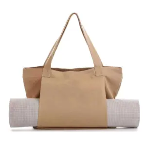 Women's Yoga Fitness Tote in tan with a yoga mat secured in the front sleeve, kuboniswe ngemuva emhlophe. Iphelele nge-OEM ODM ngokwezifiso nokusetshenziswa kwendlela yokuphila ehlukahlukene.