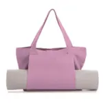 The Women's Yoga Fitness Tote holds a rolled-up yoga mat in its exterior pocket, zobrazené na bielom pozadí.