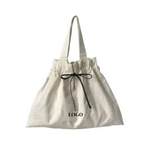 Minimalist Canvas Drawstring Tote for Women in beige with a black ribbon bow and "LOGO" Stampat fuq quddiem. Karatteristiċi ta 'top drawstring. Ordnijiet Custom OEM u ODM Disponibbli.