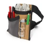 The Electrician/Repairer's Canvas Tool Pouch Belt securely holds gloves, Innealan dearga, peansail uaine, Glèineean sàbhailteachd soilleir, agus tomhas teip.