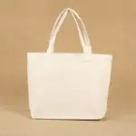 Mukautettu logo -kangaslaukku kahvoilla on esitetty kuvioitua beige -taustaa vasten.