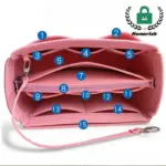 Bossa de vàter multi-compartiment impermeable en rosa, funcions 15 seccions numerades, es mostra obert amb una corretja de canell i un logotip d’honorisk. Perfecte per a la personalització OEM/ODM per adaptar -se als vostres requisits de marca.