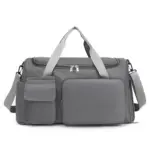 Minimālisma lielas ietilpības ceļojuma tote ir pelēka duffel soma ar gaiši pelēkiem rokturiem, priekšējās kabatas, regulējama pleca siksna, un atbalsta ODM/OEM pielāgošanu.