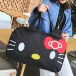A person holds a large black Cute Cat-Themed Women's Travel Bag featuring a Hello Kitty face with a red bow and white whiskers—ideal for OEM/ODM customization.