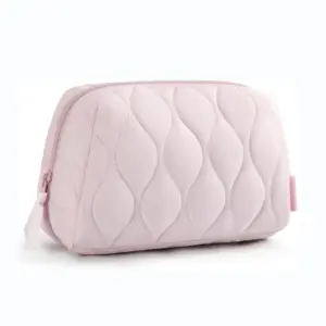 A light pink puffy makeup bag with beautiful wavy quilted stitching and a smooth zipper, showcasing the quality and customization potential we offer.
