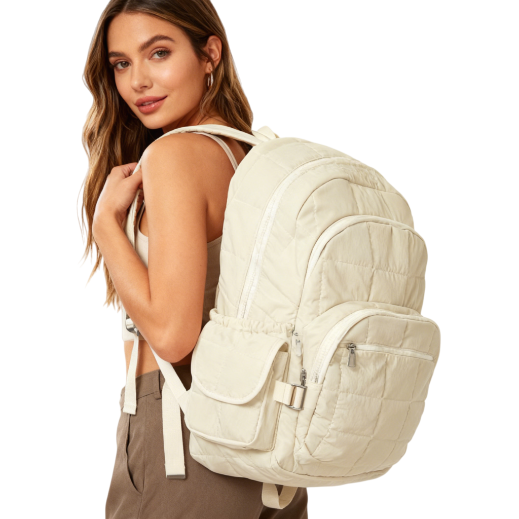 A person wearing the beige Everyday Backpack in a city setting, showing its sleek, minimalist profile.